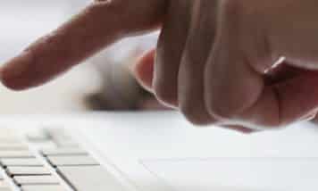 Persona utilizando un ordenador para acceder al canal de denuncias obligatorio