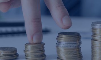 Representación visual del crecimiento salarial con monedas apiladas como ejemplo de cómo se aplica la subida salarial a la nómina