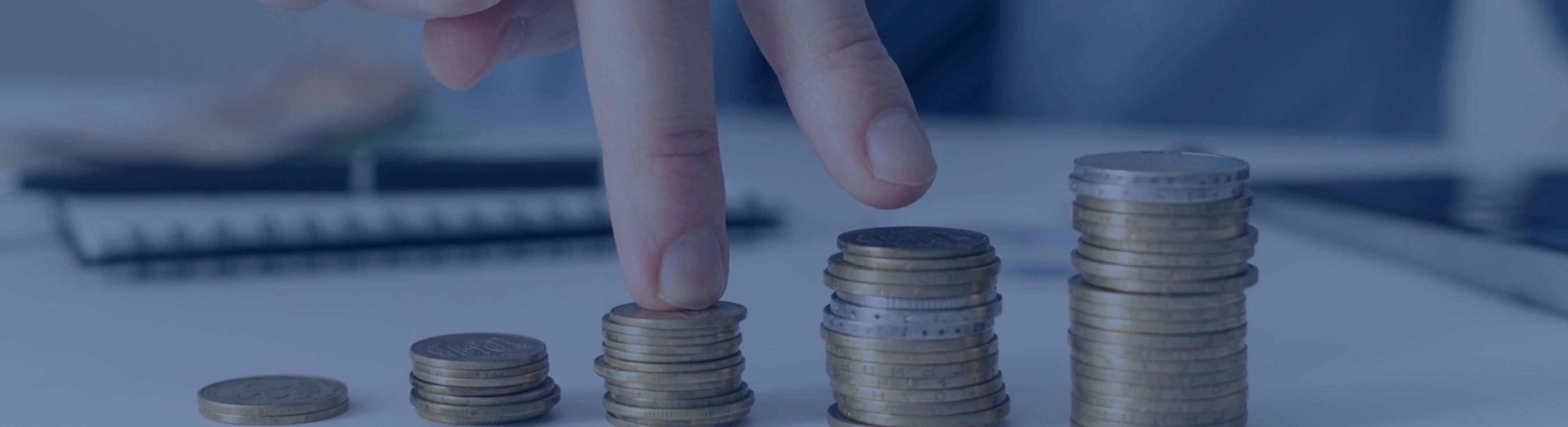 Representación visual del crecimiento salarial con monedas apiladas como ejemplo de cómo se aplica la subida salarial a la nómina